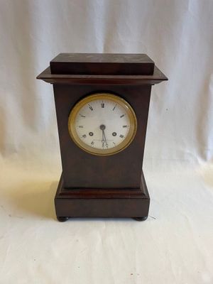 une petite horloge en bois sur fond blanc