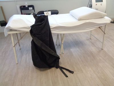 une table blanche sur laquelle est posé un sac noir