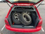 two tires in the trunk of a red car