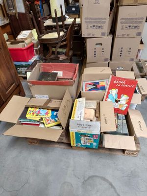 de nombreux cartons remplis de livres posés par terre dans une pièce