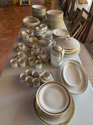 une longue table sur laquelle sont disposées de nombreuses assiettes et bols