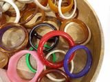 a wooden bowl filled with lots of different colored rings