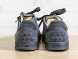 pair of black shoes on a wooden table with a white wall in the background