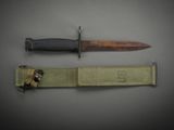 a knife that is laying next to a belt