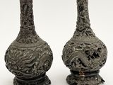 deux vases en argent posés l'un à côté de l'autre sur une surface blanche