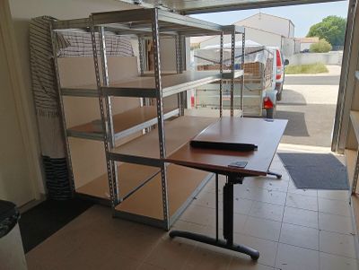a room with a desk and shelves in it