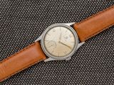 une image représentant une montre avec un bracelet en cuir marron sur un fond noir