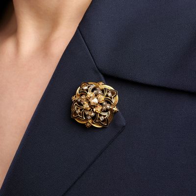 a close up of a person wearing a suit and a brooch
