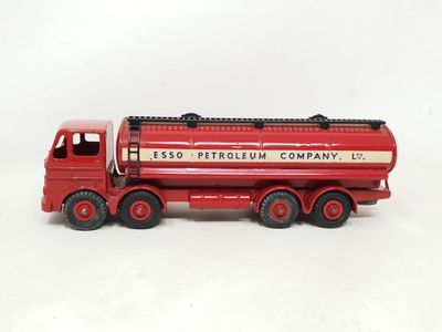 un camion jouet rouge posé sur une surface blanche