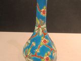 un vase bleu avec des fleurs posé sur une table