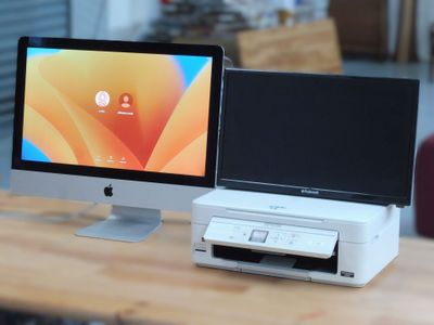 deux ordinateurs posés sur un bureau, équipés d'un écran et d'un clavier