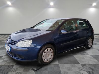 La voiture bleue est garée sur le sol à damier du garage.