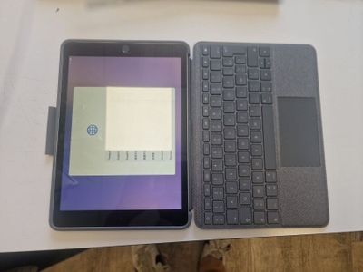 a tablet and a laptop on a table next to each other