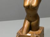 sculpture représentant un torse féminin assis sur un bloc de bois