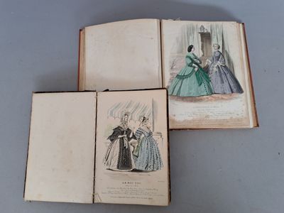 trois livres sur lesquels figurent des dessins de femmes en robe, posés sur une table
