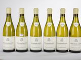six bouteilles de vin blanc sont alignées sur une table