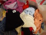 a pile of clothes in a bag on a bed