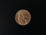 a close up of a gold coin on a black surface