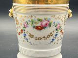 a white vase with a gold rim and flowers on it