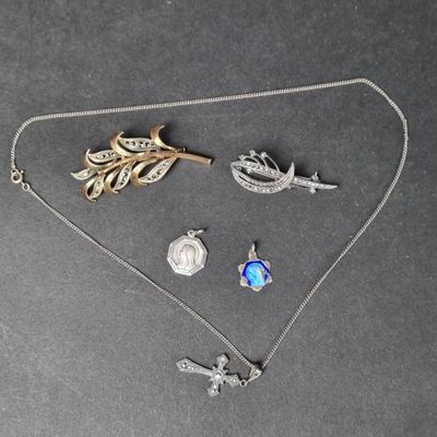 un collier en argent orné d'un oiseau, d'une feuille et d'une broche en forme d'oiseau