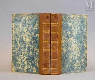 un vieux livre à la couverture bleue et jaune posé sur une table blanche