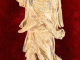 statue of an angel on a red velvet surface with a red background