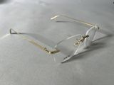clear and gold rimmed eyeglasses on a white surface