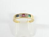 a close up of a gold ring with three different colored stones