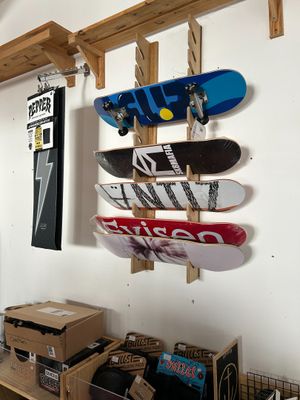 Il y a beaucoup de skateboards accrochés au mur dans cette pièce