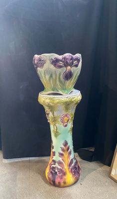 un vase posé par terre à côté d'un cadre photo
