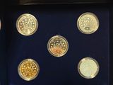 an image of a person holding a box with six different coins in it
