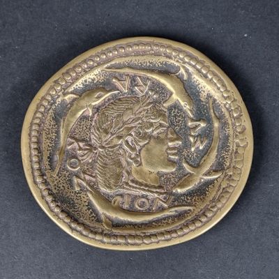 a close up of a gold coin with a woman ' s face on it