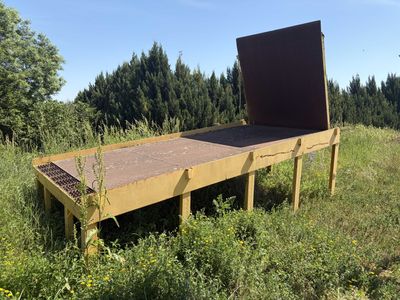 a wooden bench in the middle of a grassy field