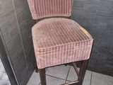une chaise rose posée dans un coin de la salle de bains