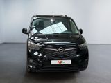 the front view of a black car parked in a showroom