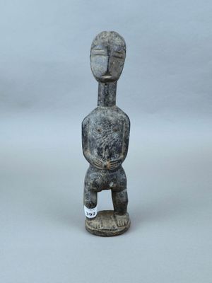statue d'un homme coiffé d'un chapeau, assis sur un socle en bois