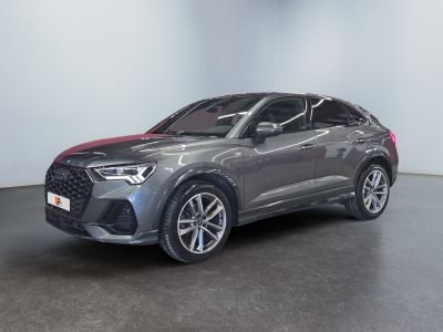 a grey audi qx parked in a room with a black floor
