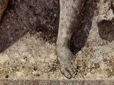 a statue of a woman with her foot on a stone block