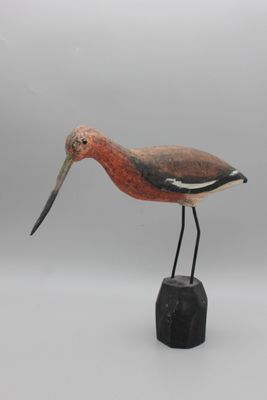 sculpture représentant un oiseau au long bec, perché sur un rocher