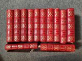 Plusieurs livres rouges sont empilés les uns sur les autres sur une surface grise