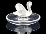 a glass swan sitting on top of a glass plate