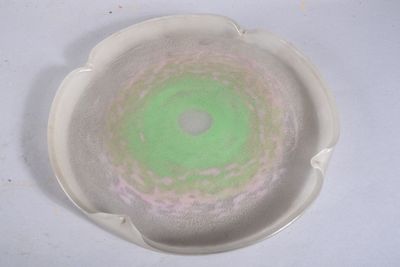 une assiette blanche ornée d'un motif vert et rose