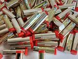 a pile of red and silver lipsticks on a white surface