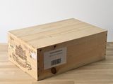 une boîte en bois portant une étiquette, posée sur un plancher en bois