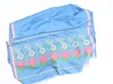 a blue scarf with pink flowers on it on a white surface