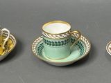 three cups and a saucer sitting on a table