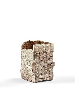 une image montrant un gros plan d'un vase posé sur une surface blanche