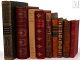 plusieurs vieux livres sont alignés sur une surface blanche