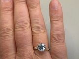 a person ' s hand with a diamond ring on it