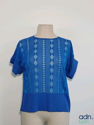 un gros plan sur le torse d'un mannequin vêtu d'une chemise bleue